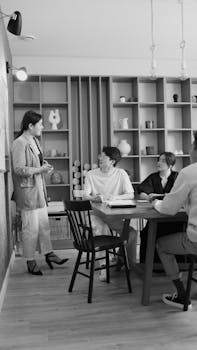 A team discussing a project in a modern office setting. Black and white photo.