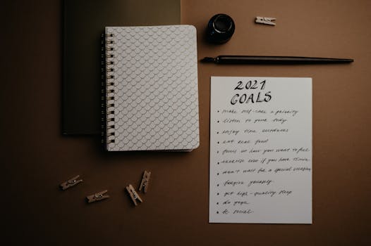 Aesthetic flatlay of notebooks and a 2021 goals list in elegant calligraphy.