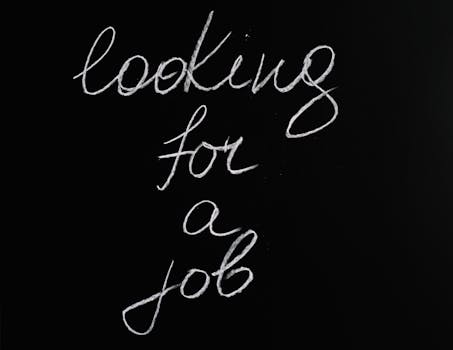 Cursive 'looking for a job' text on a black chalkboard, conveying job search concept.